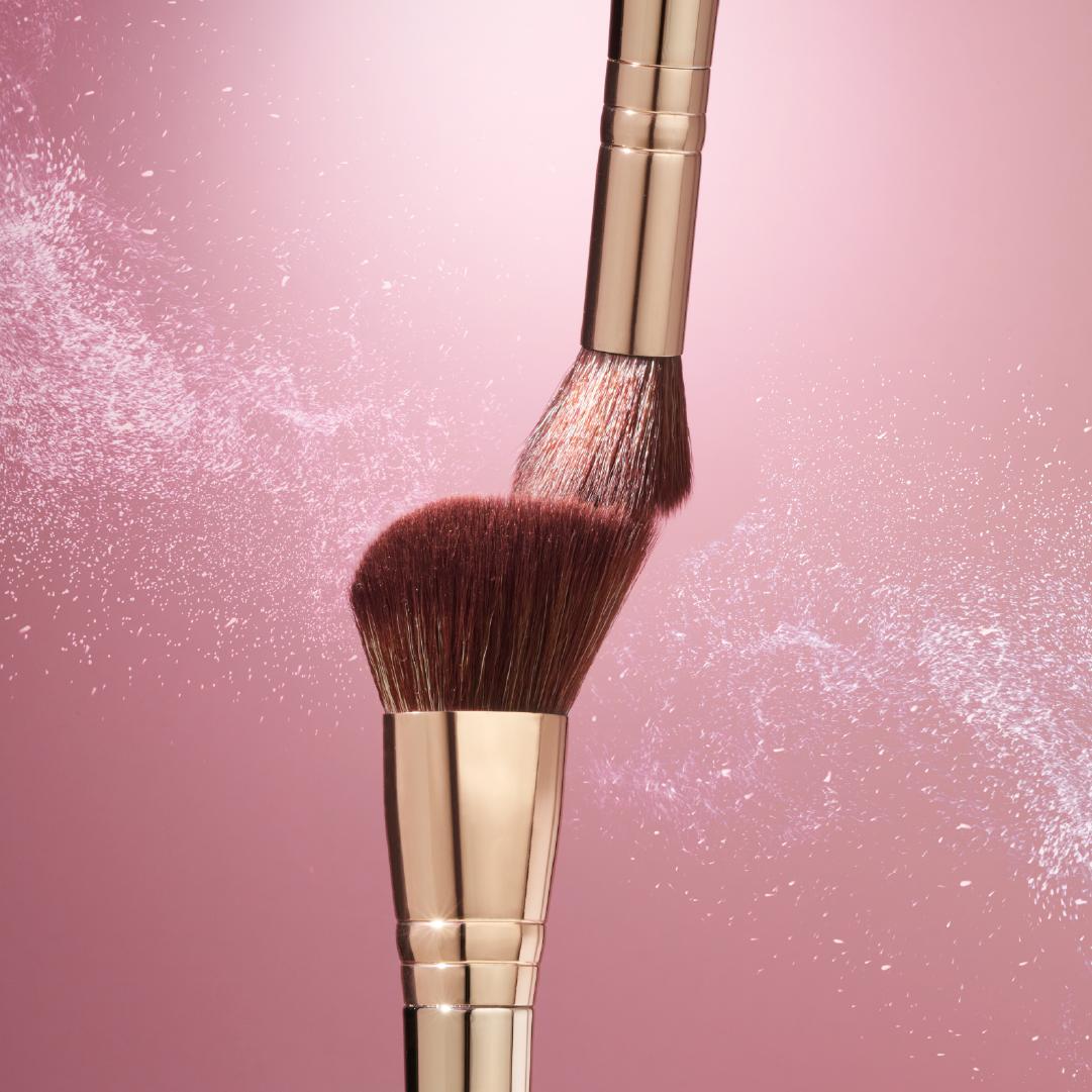 One makeup brushe with two synthetic bristles, one with a flat angled end.